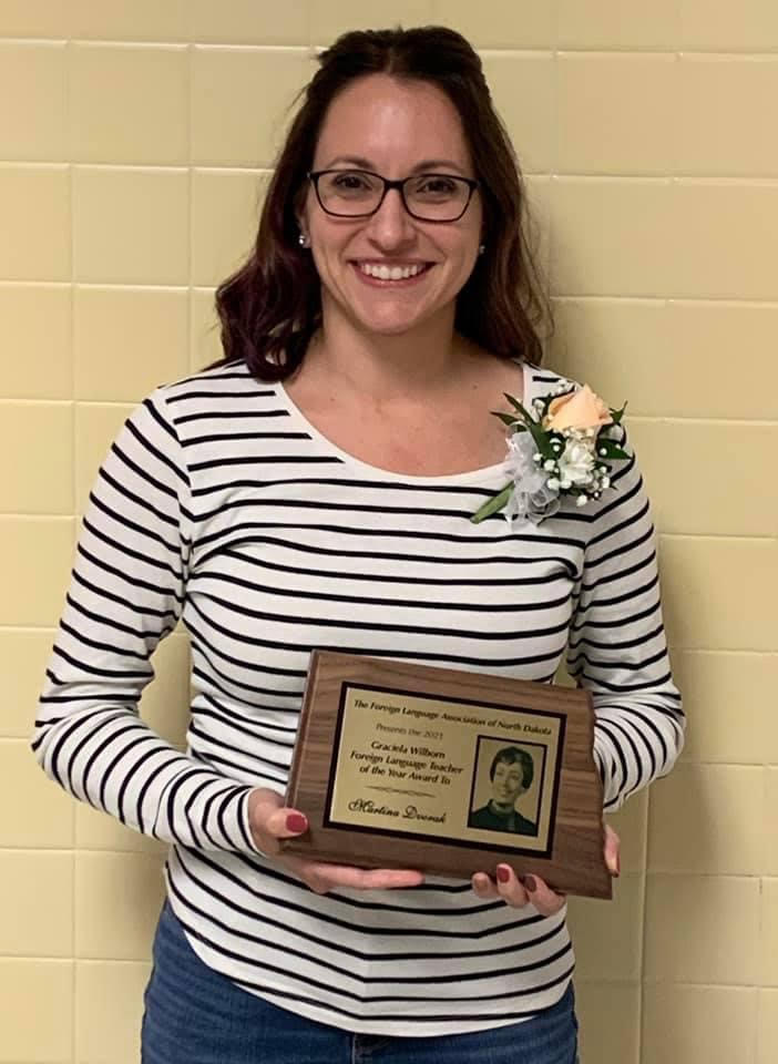 woman standing holding an award