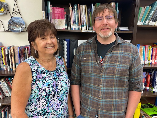 woman and man with glasses posing for the camera