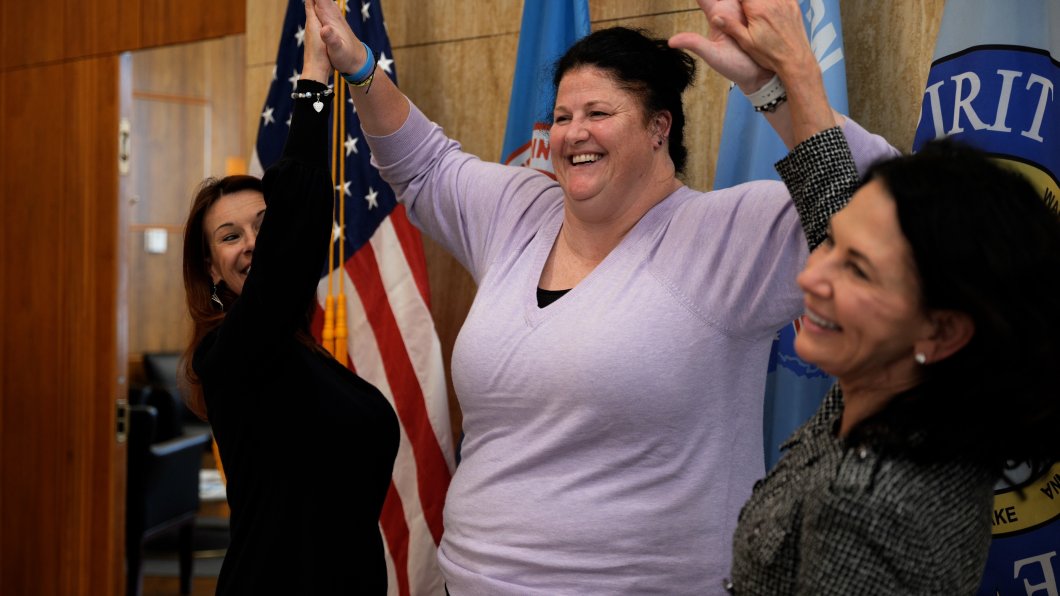Peterson high-fiving State Superintendent Kirsten Baesler and Lieutenant Governor Tammy Miller