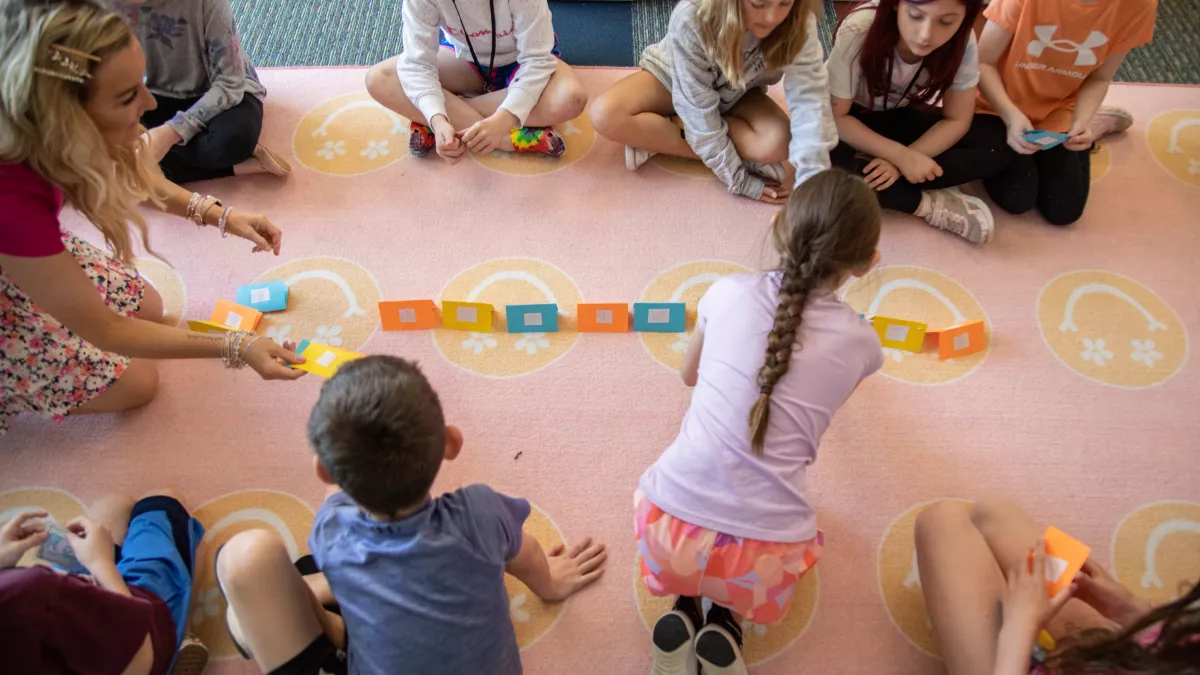 group of elementary school kids sitting on classroom floor