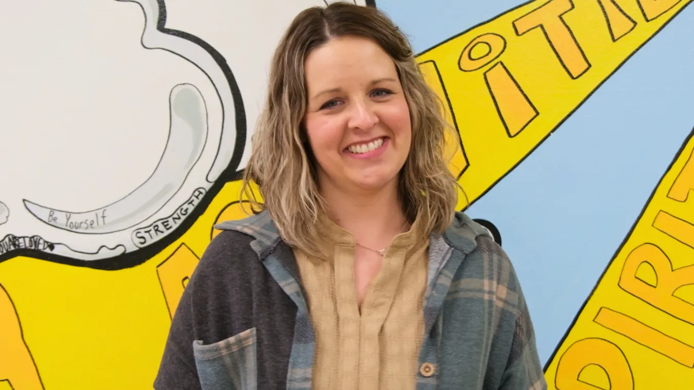 Portrait of Katie Weiner, an instructional paraprofessional at Thompson Elementary School and a finalist for North Dakota United's 2027 Education Support Professional of the Year. She smiles in front of a colorful school mural.