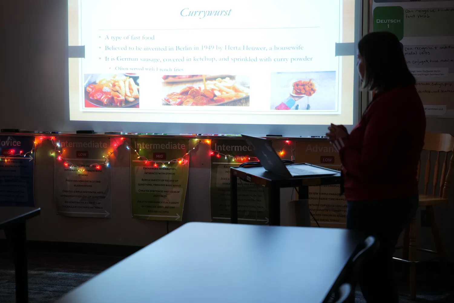 teacher standing in dark room giving a presentation