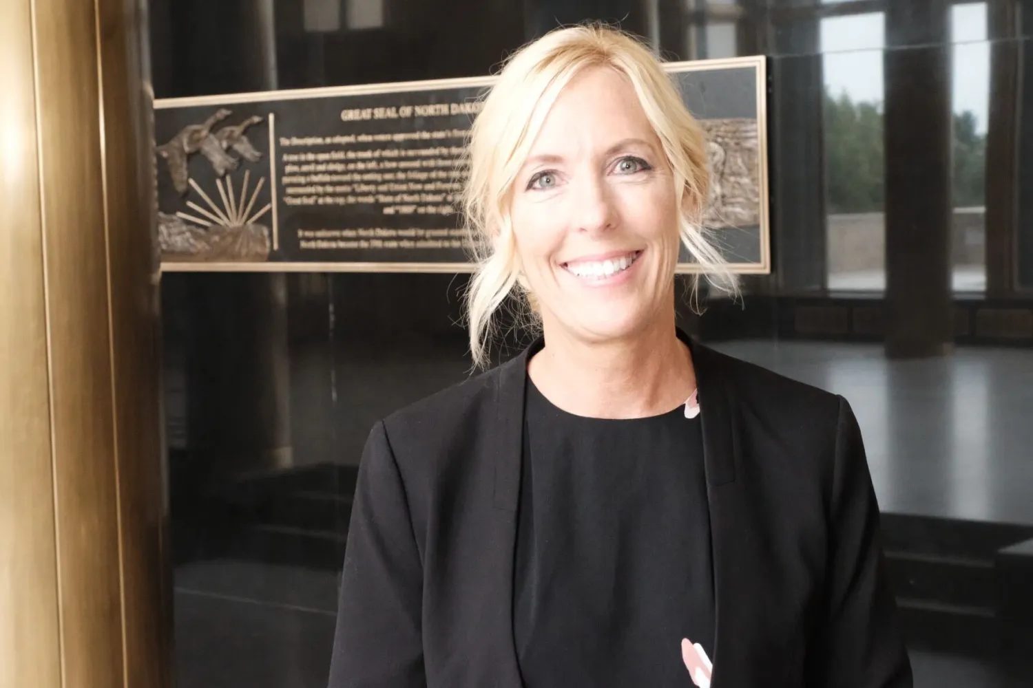 headshot of woman wearing black suit smiling