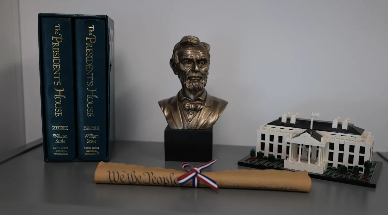 A bronze bust of Abraham Lincoln accompanied by a Lego set of the White House and a copy of the U.S. Constitution sit on a table in Landen Schmeichel's classroom..