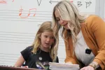 Minot elementary music instructor Risha Allen works one-on-one with a student in her classroom.