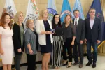 group of people standing in front of flags