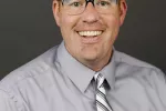 headshot of man wearing glasses