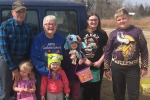 kids standing with grand parents outside in the fall