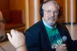 man sitting at table being interviewed for a radio show