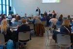 group of people still ing at tables in a conference room