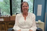 Woman smiling in front of office window.