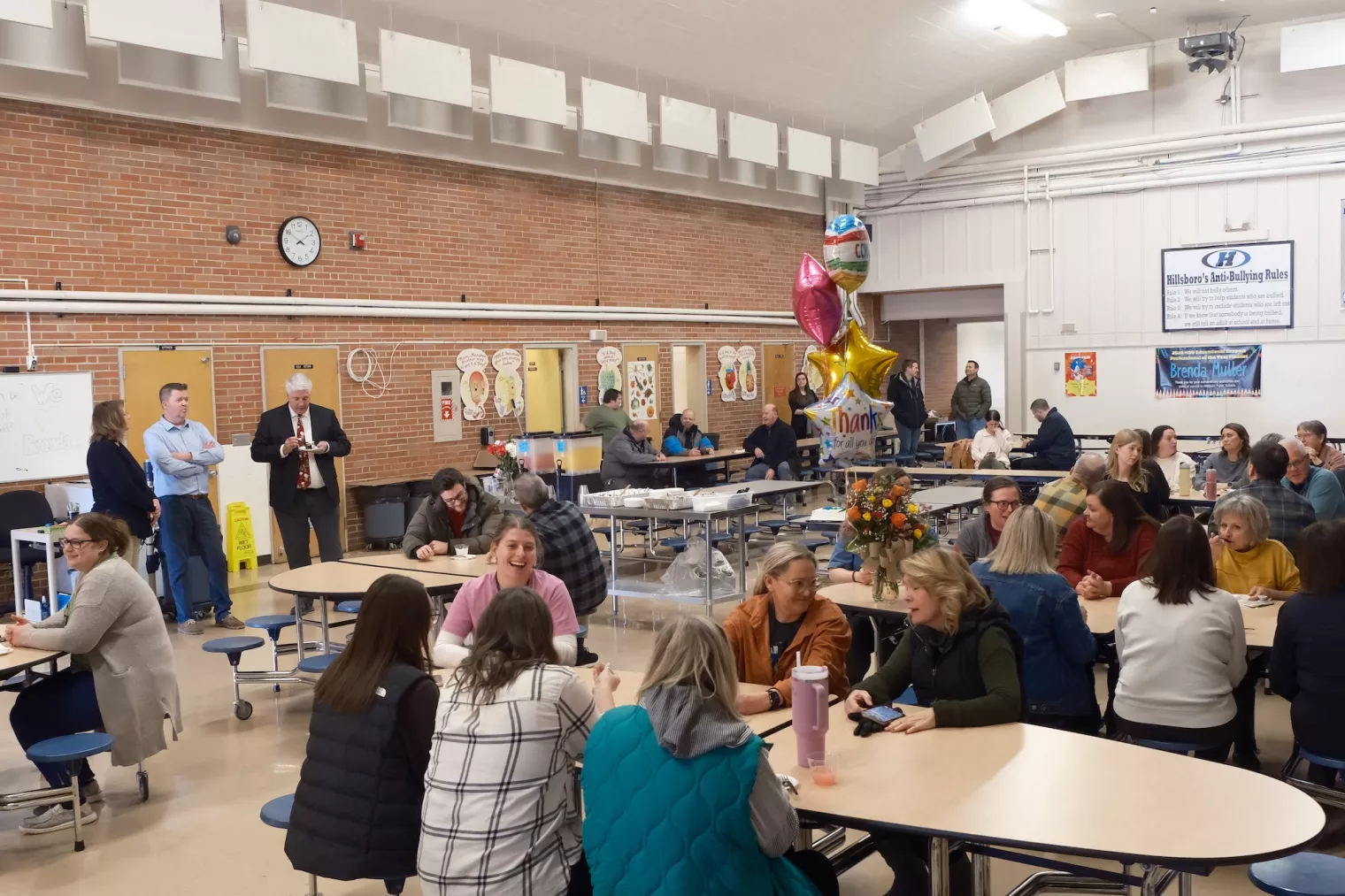 School cafeteria in Hillsboro, ND, filled with faculty and staff for celebration.