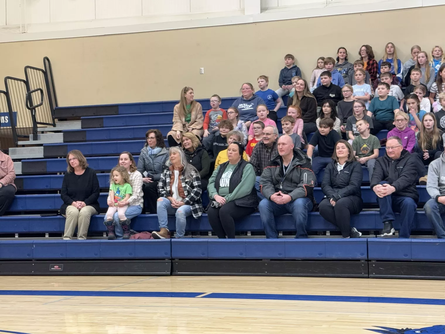 ESP of the Year finalist Brenda Muller sits in stands with family and the elementary school students at her award ceremony.