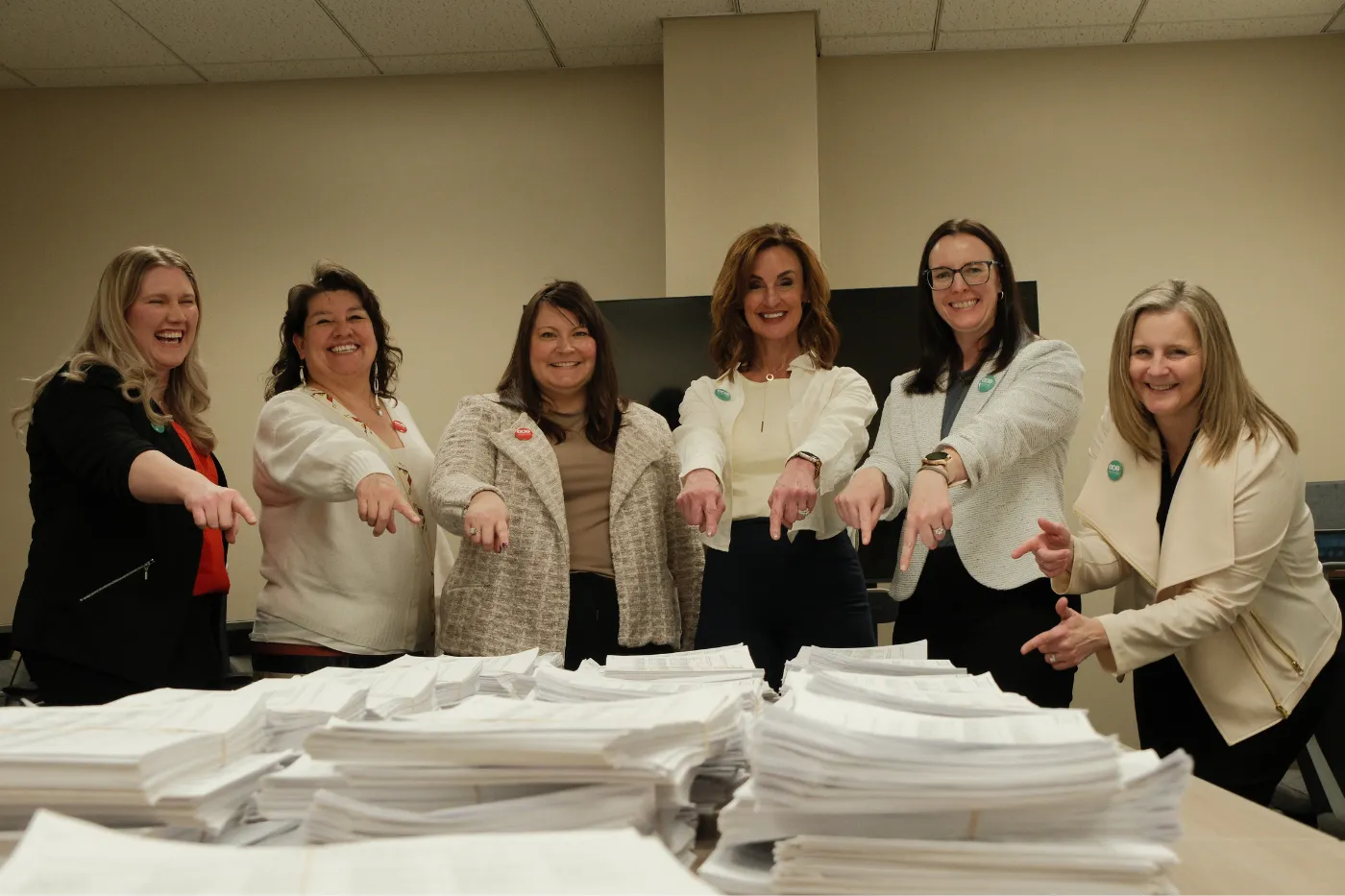Coalition members, from left, Jessica Edland, Cheryl Kary, Ashley Gaschk, Robin Nelson, Michelle Wagner and Amy Jacobson smile and point toward stacks of completed petition signatures.