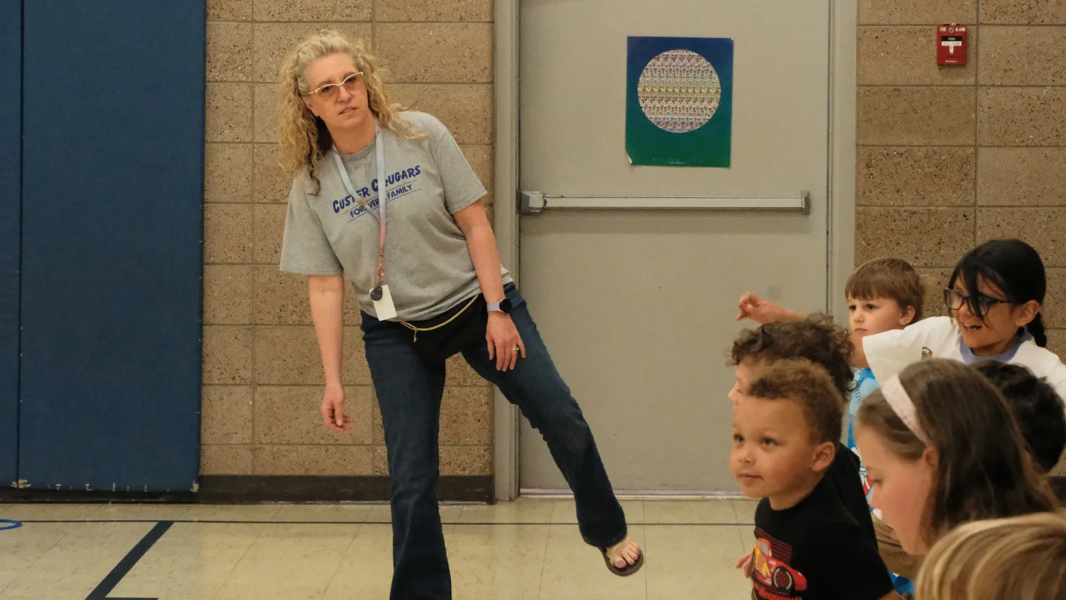 Dawn Ressler demonstrates a movement exercise as a group of elementary students watches and prepares to follow her lead.