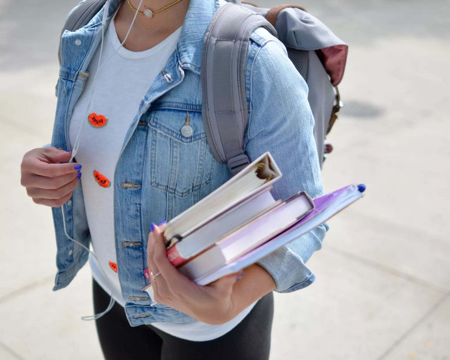 woman carrying binders walking to college