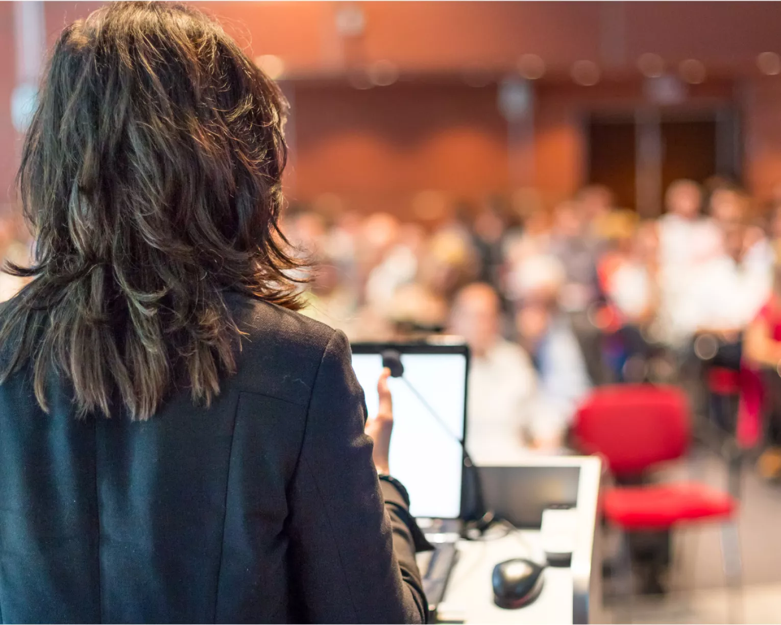 image of back of woman speaking to a crowd