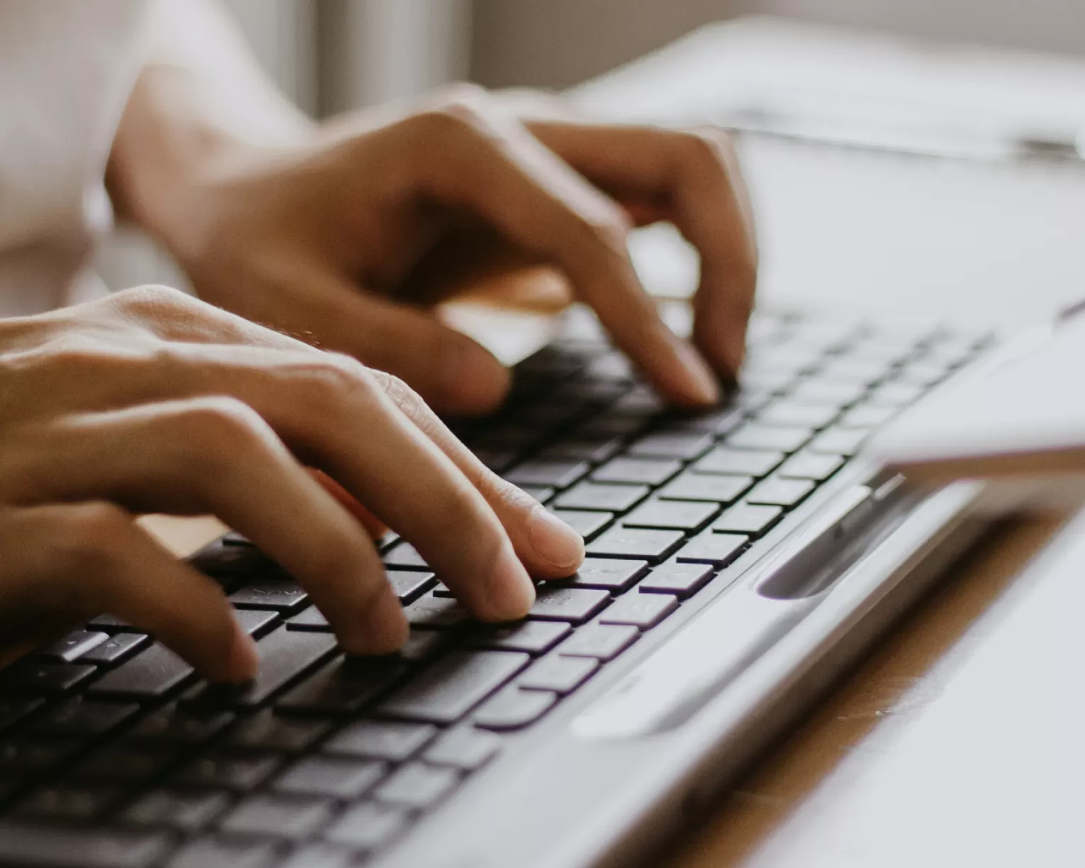 closeup of hands typing on a keyboard