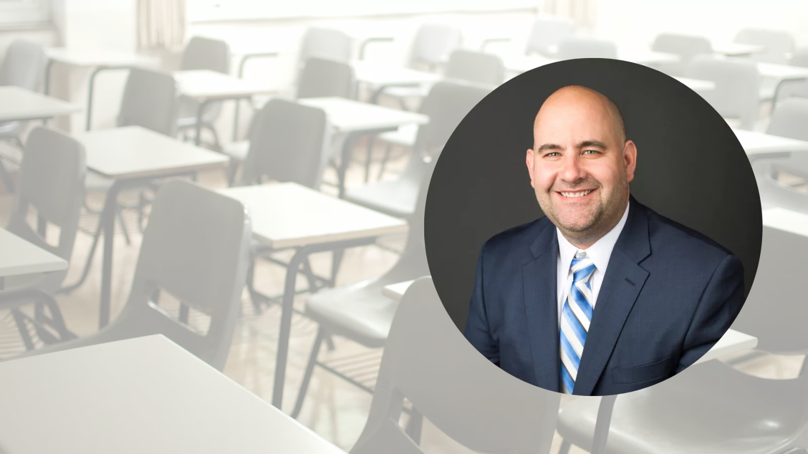 headshot of man wearing suit and tie