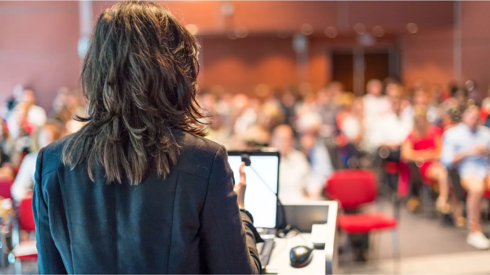 image of back of woman speaking to a crowd