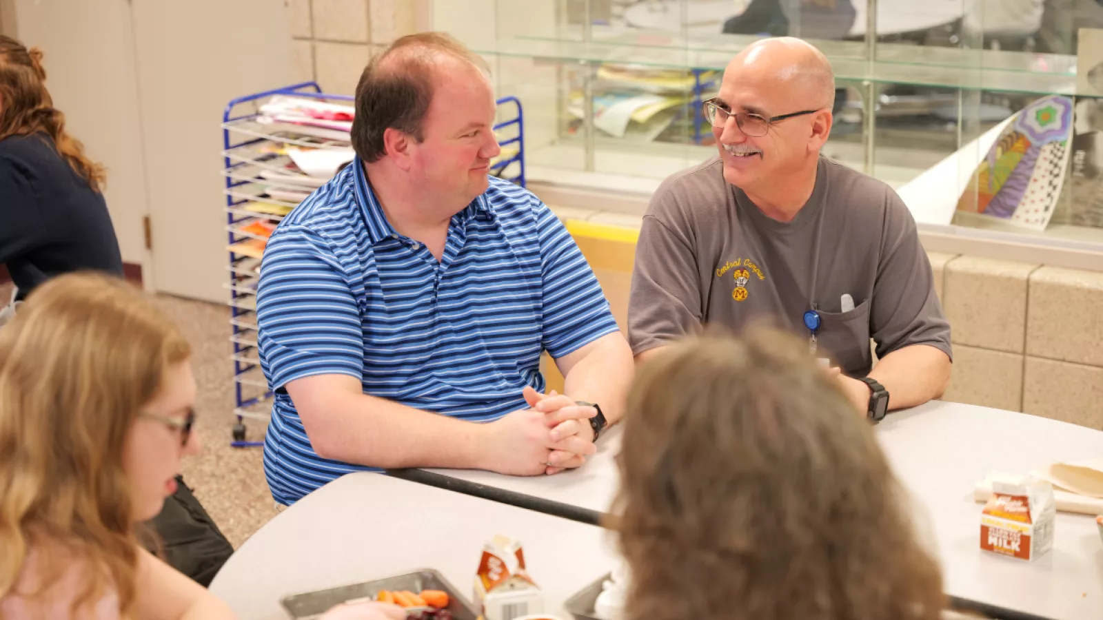 man sitting at table with students