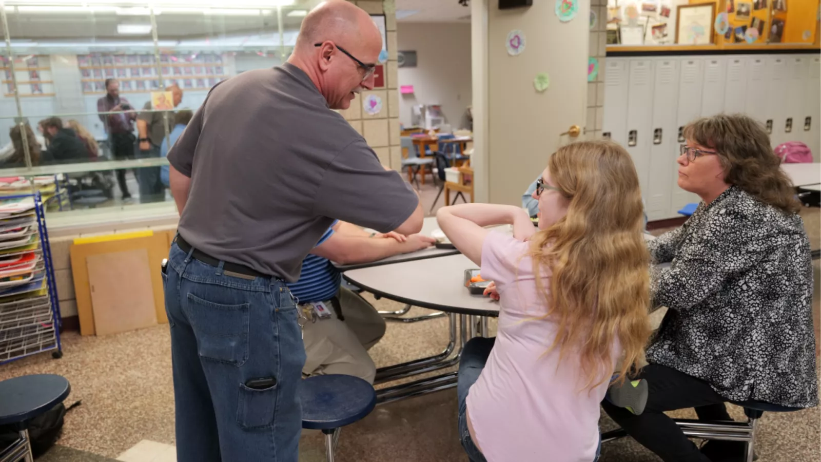 image of man giving a student at in a cafeteria a fist bump