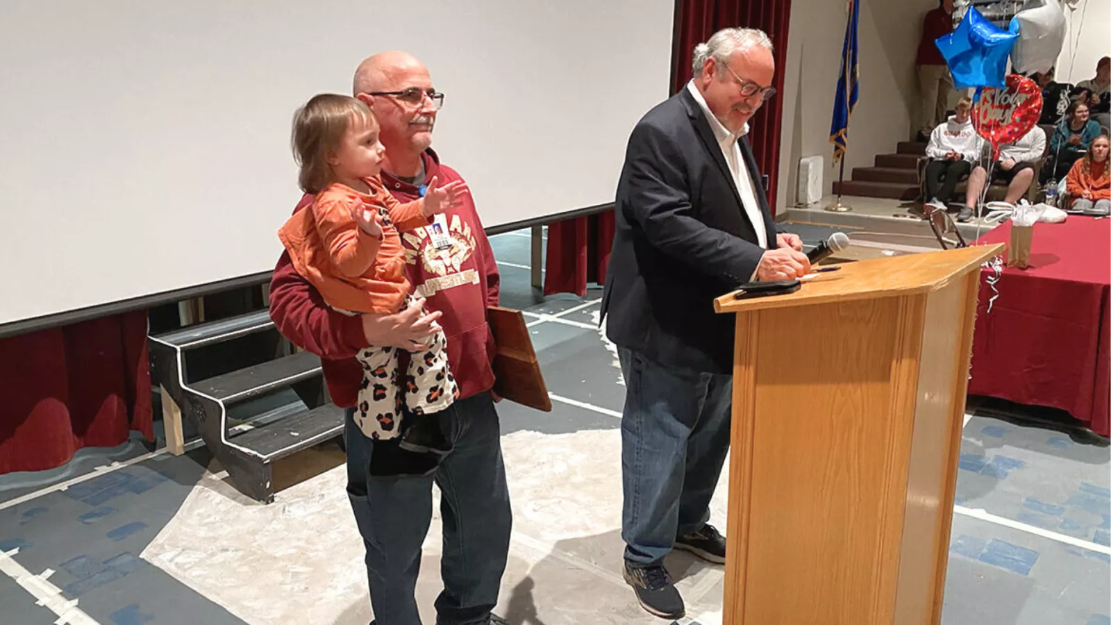 man holding child receiving the ND ESP of the year award