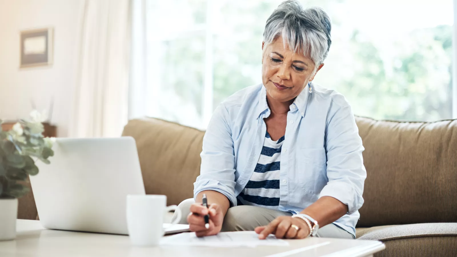 retired woman sitting in front of computer reviewing paperwork