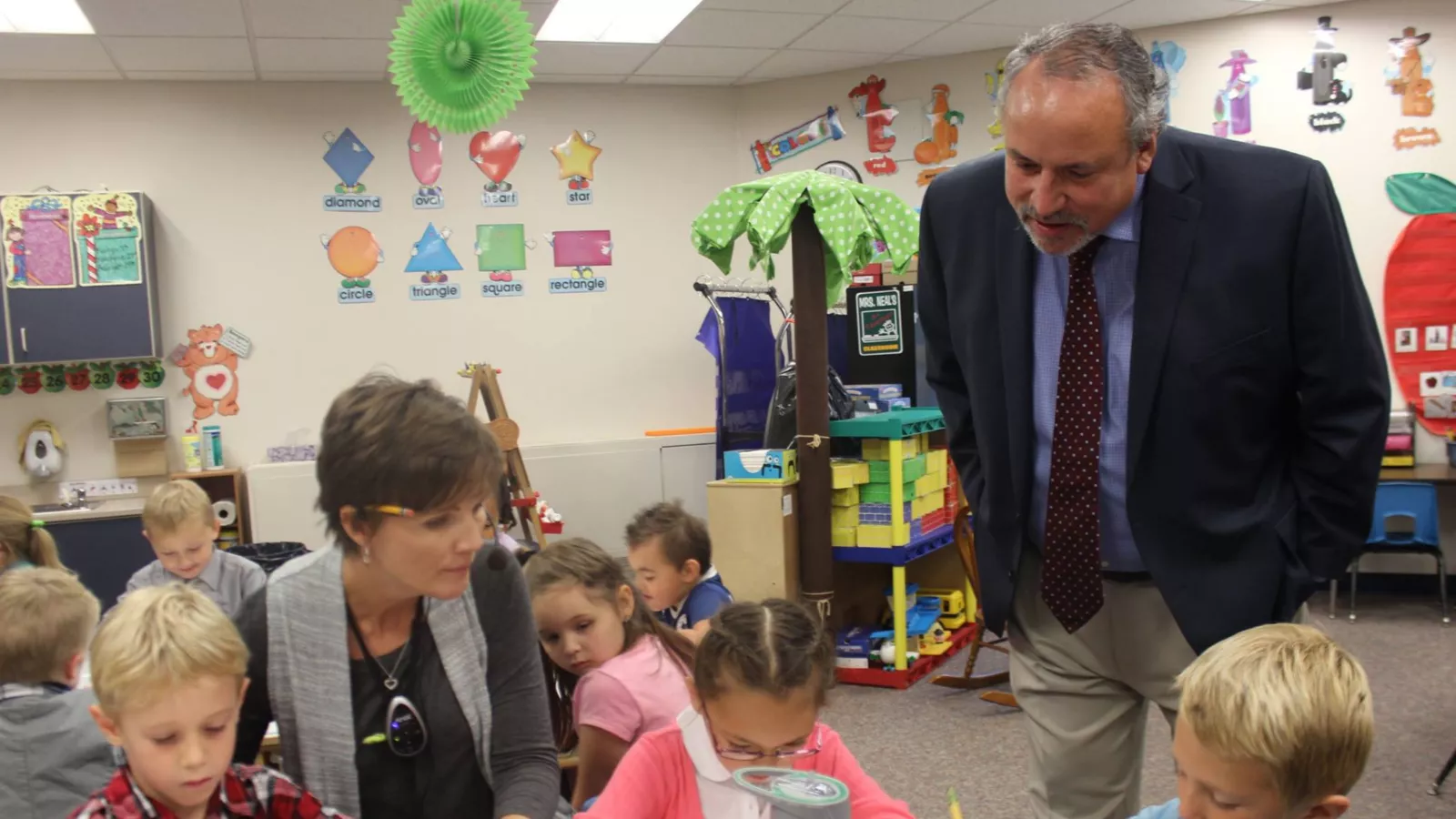 ND United President Nick Archuleta looks on with a smile as a teacher instructs a small reading group.