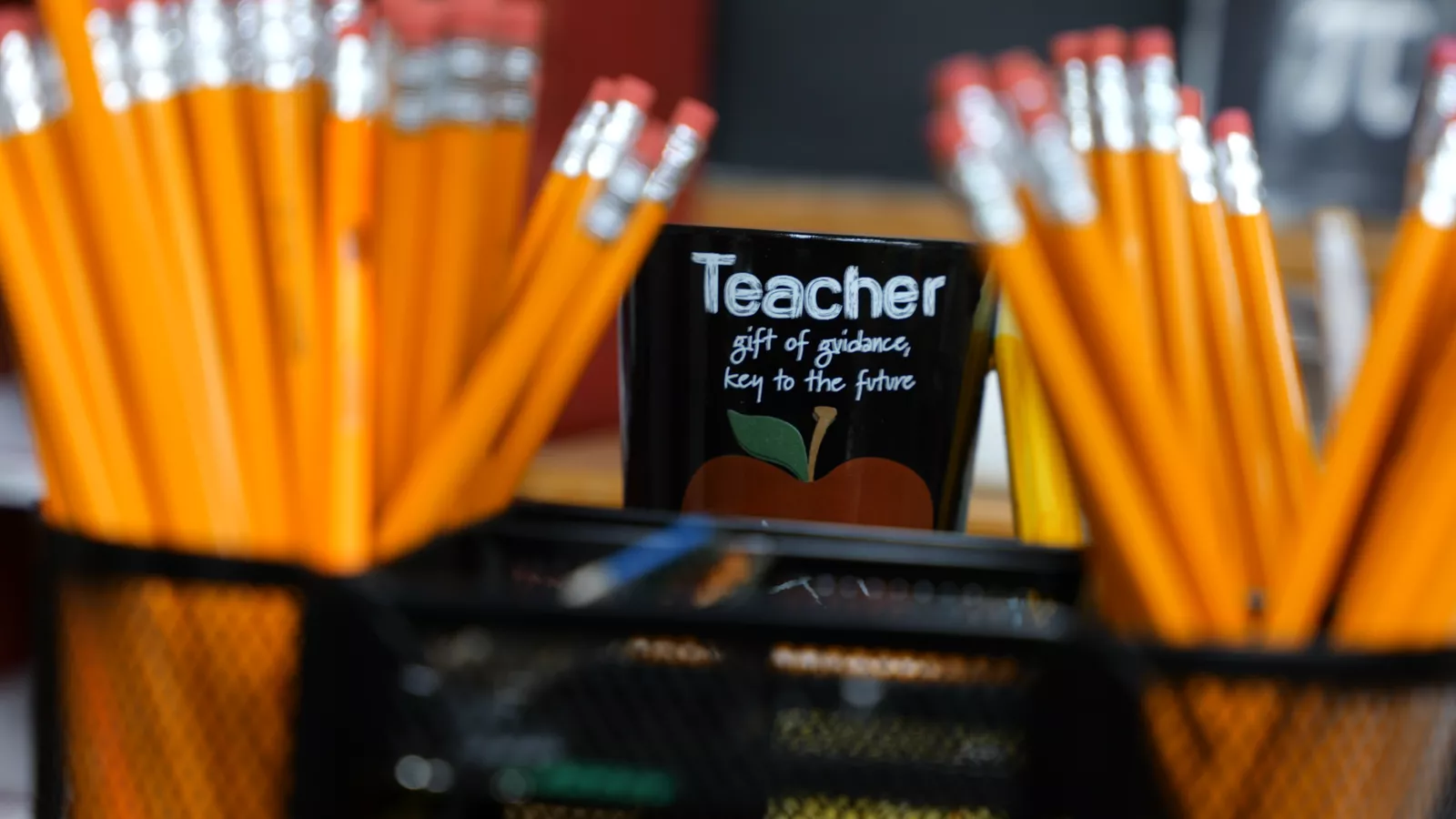 Mug with kind words about teachers behind some #2 pencils