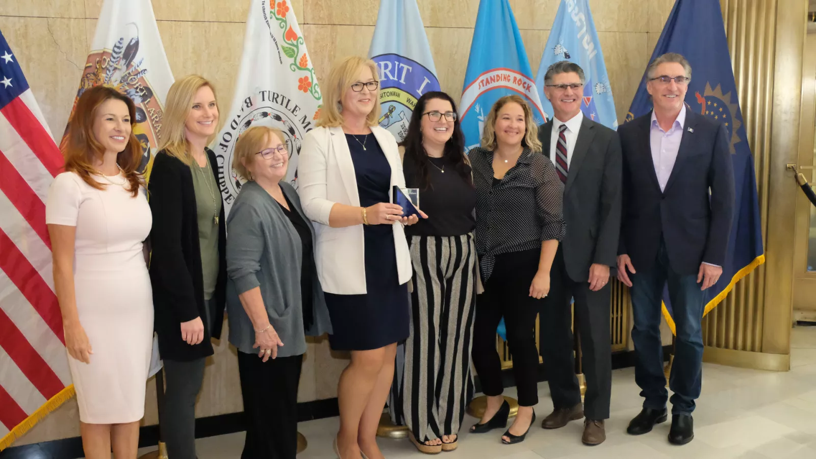 group of people standing in front of flags