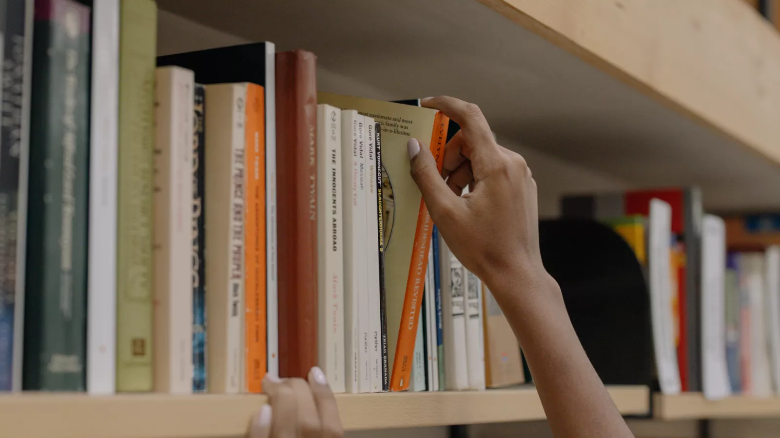 hand reaching for a book in library