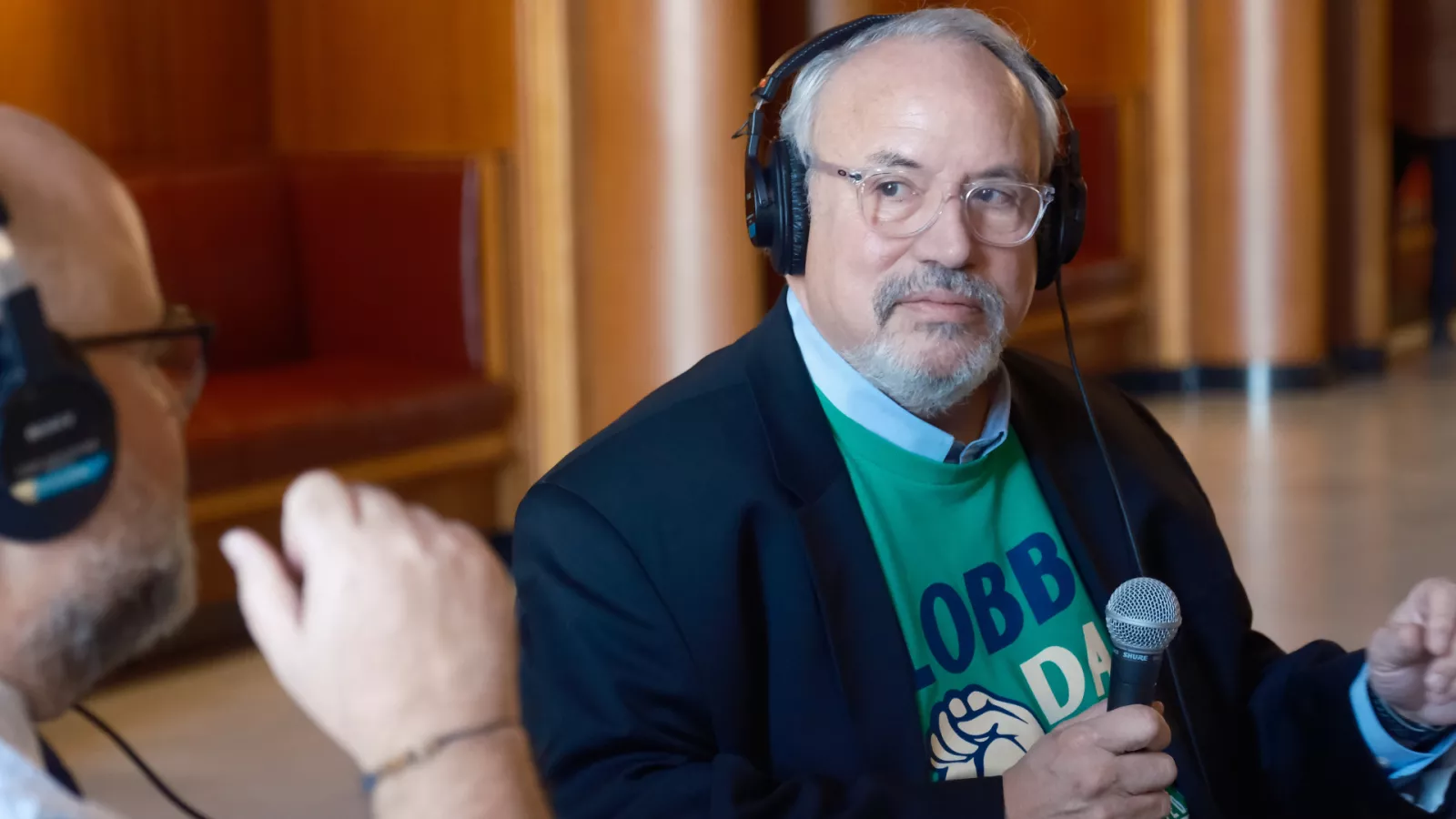 man sitting at table being interviewed for a radio show