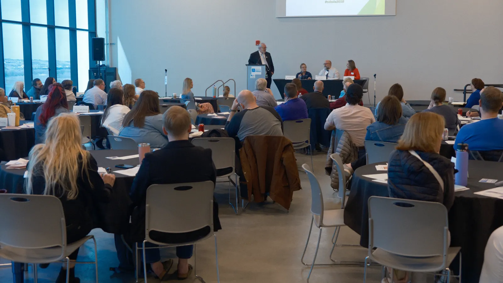 group of people still ing at tables in a conference room
