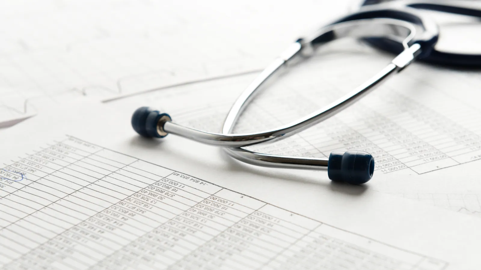 A stethoscope sits atop a medical billing statement