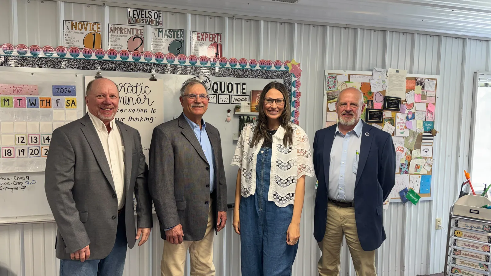Rep. Dave Rustebakke, Sen. Randy Lemm and Rep. Mike Beltz stand with 2026 North Dakota Teacher of the Year Frannie Tunseth in her classroom at May-Port CG Middle School during a visit to observe teaching and learning.