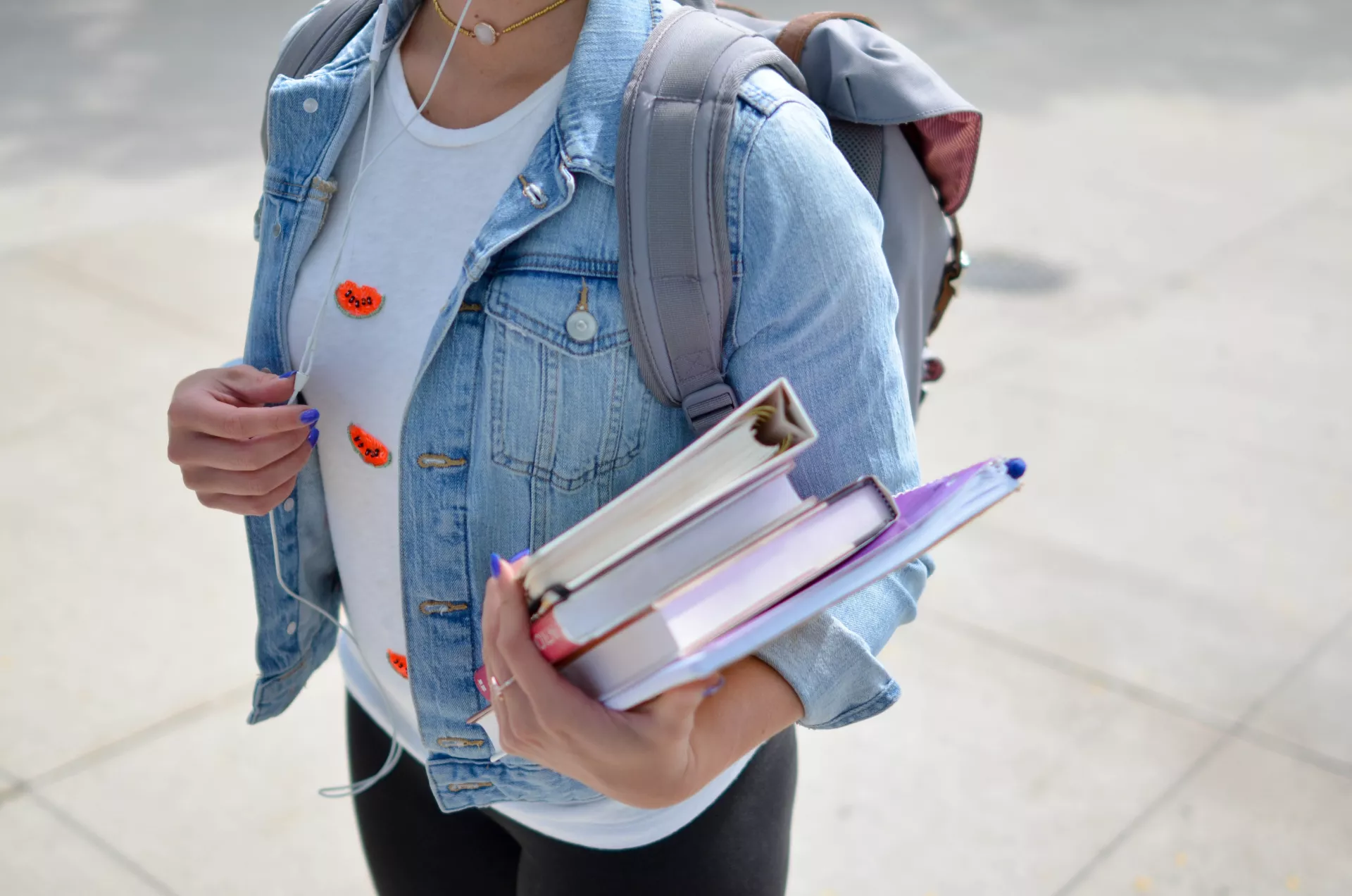 woman carrying binders walking to college