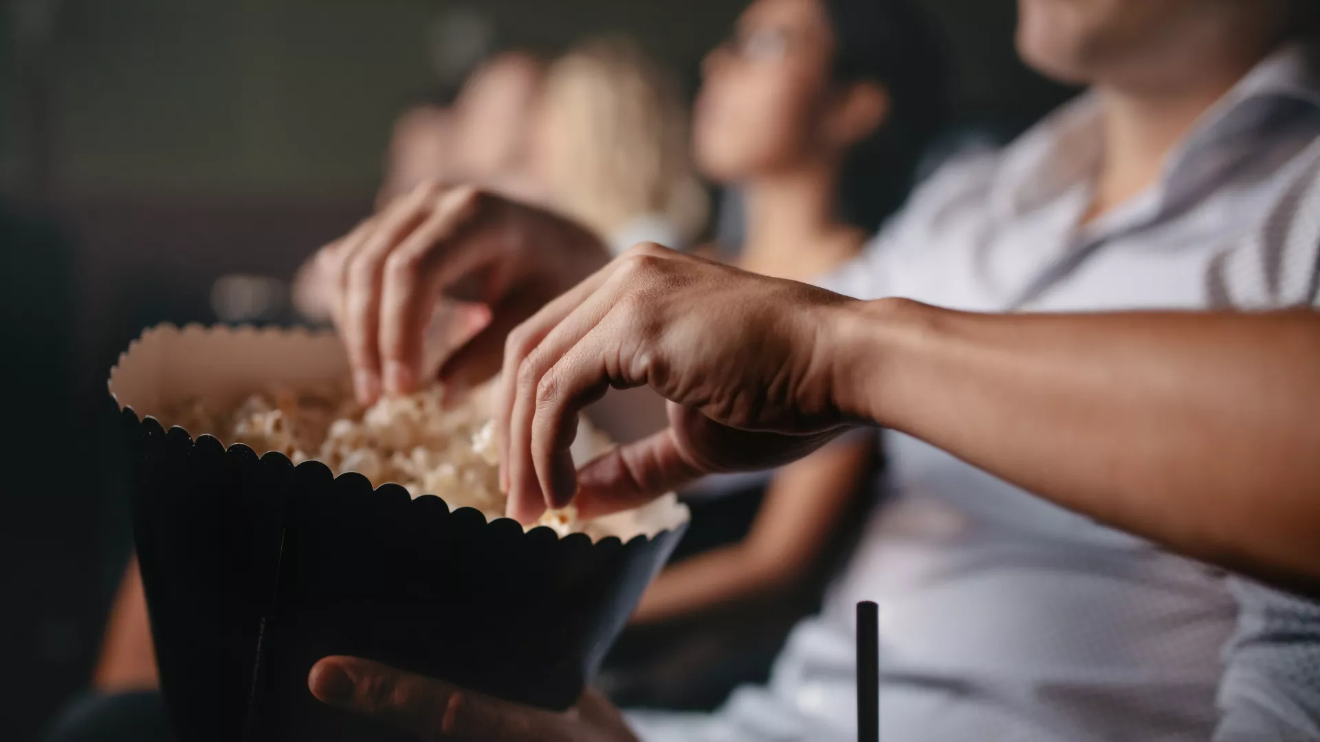 people eating popcorn at a movie theatre