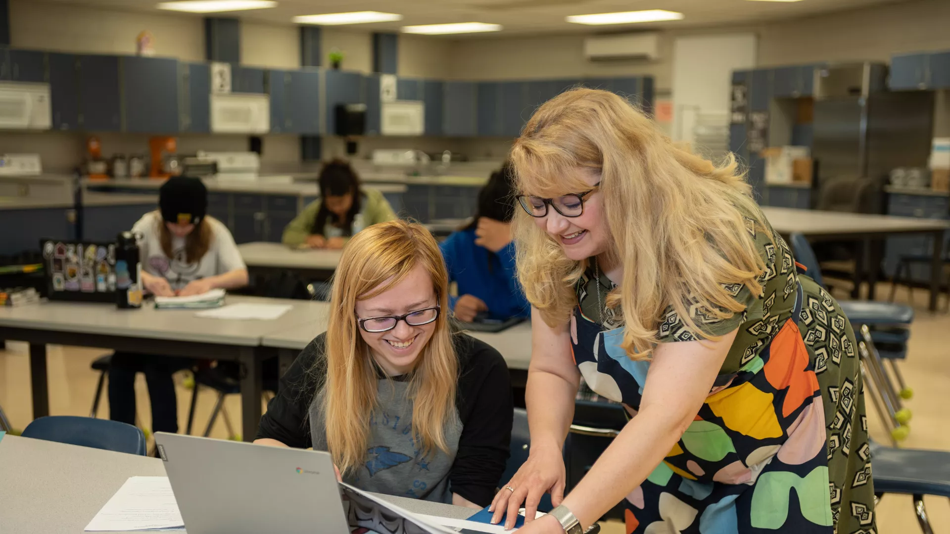 Female educator helping student at her computer