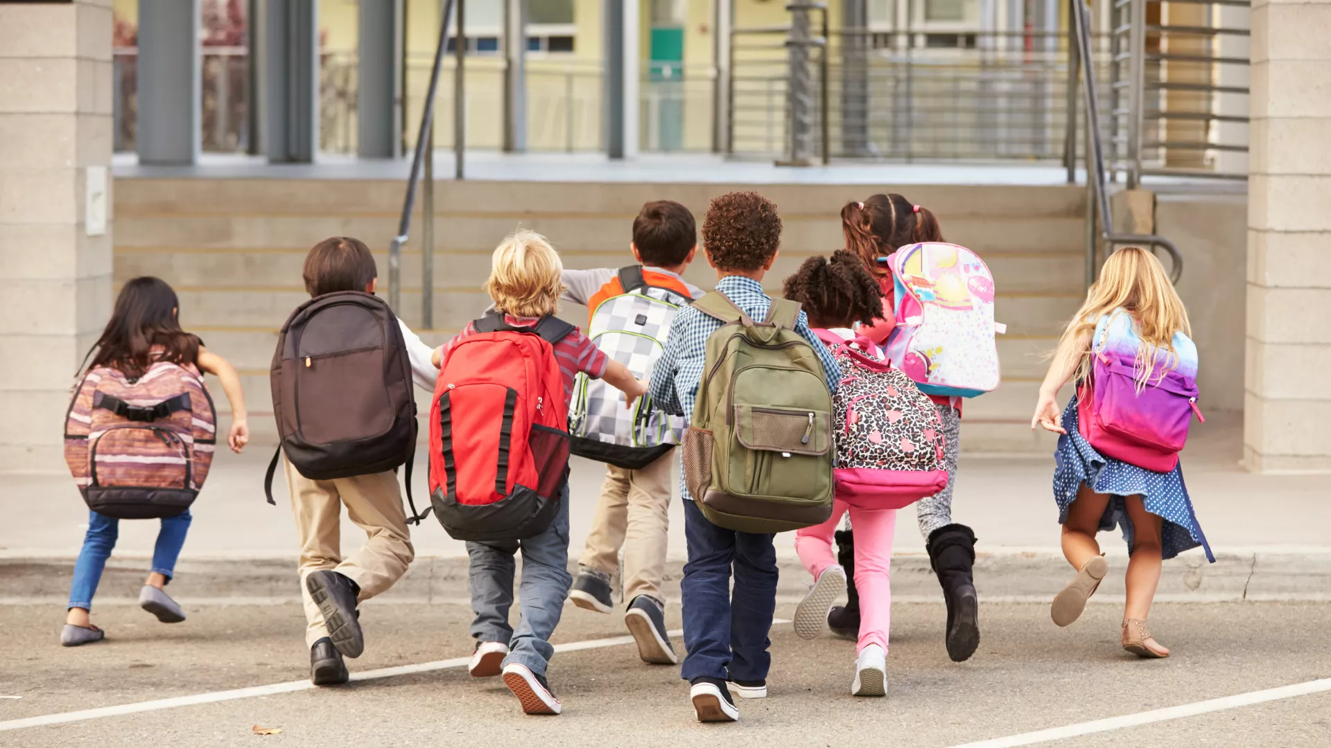 images of young students running with their backpacks on