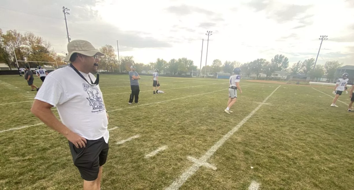 man wearing hat standing on a football field