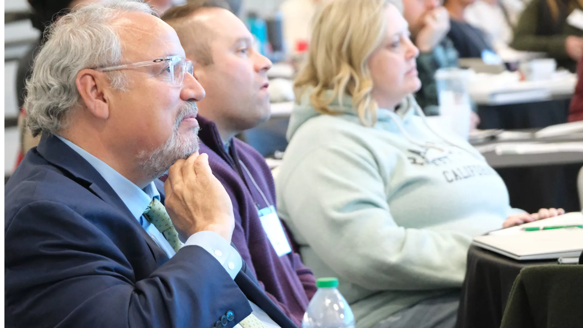 people sitting in audience listening to speaker