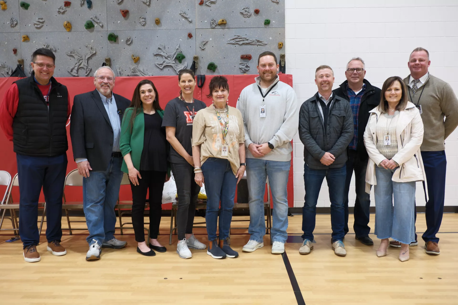 Group of educators stand together in gym at Myrhe Elementary School in Bismarck to honor Joan Hall, a finalist for ND ESP of the Year.