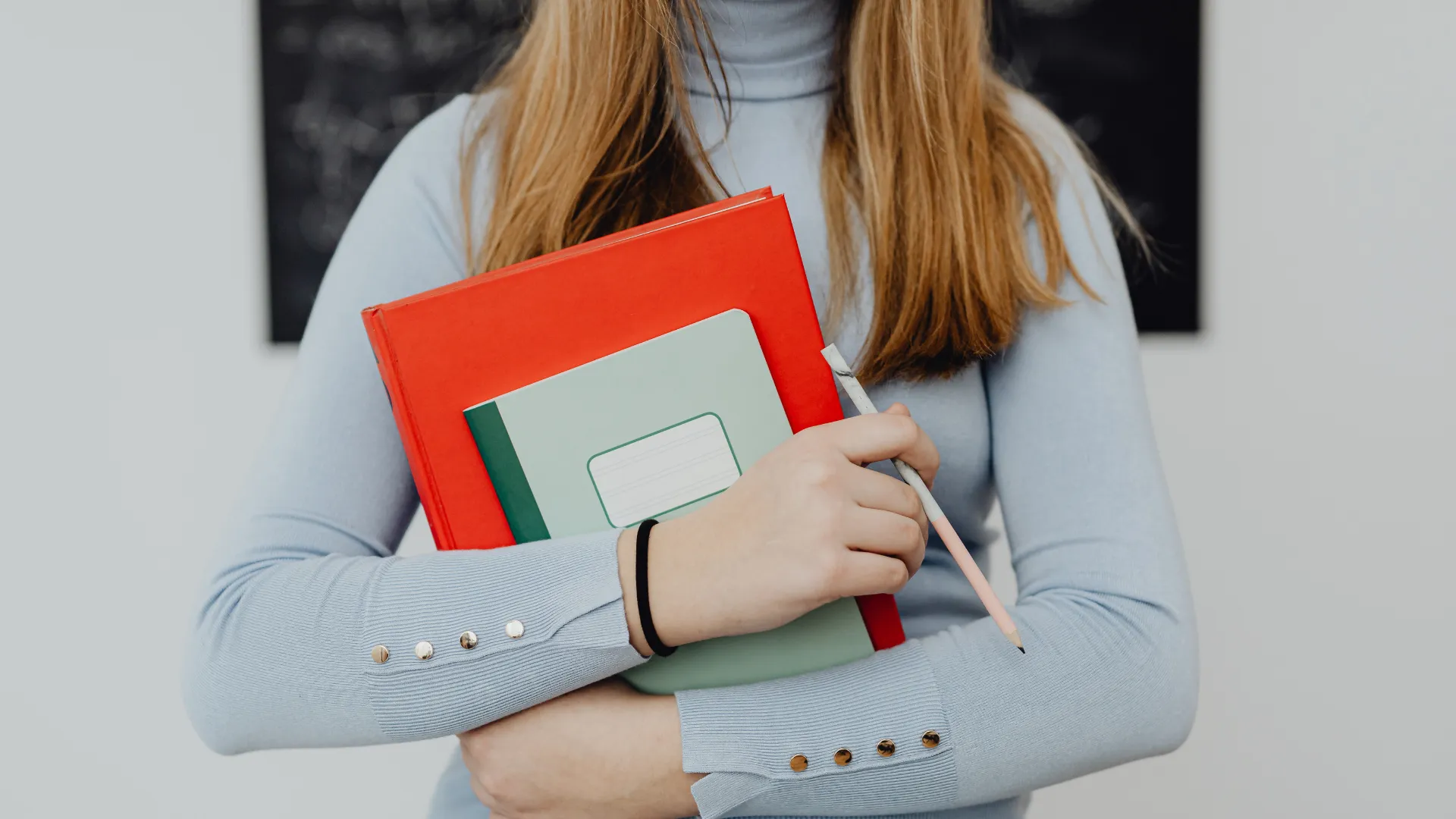 woman staking holding books against her chest