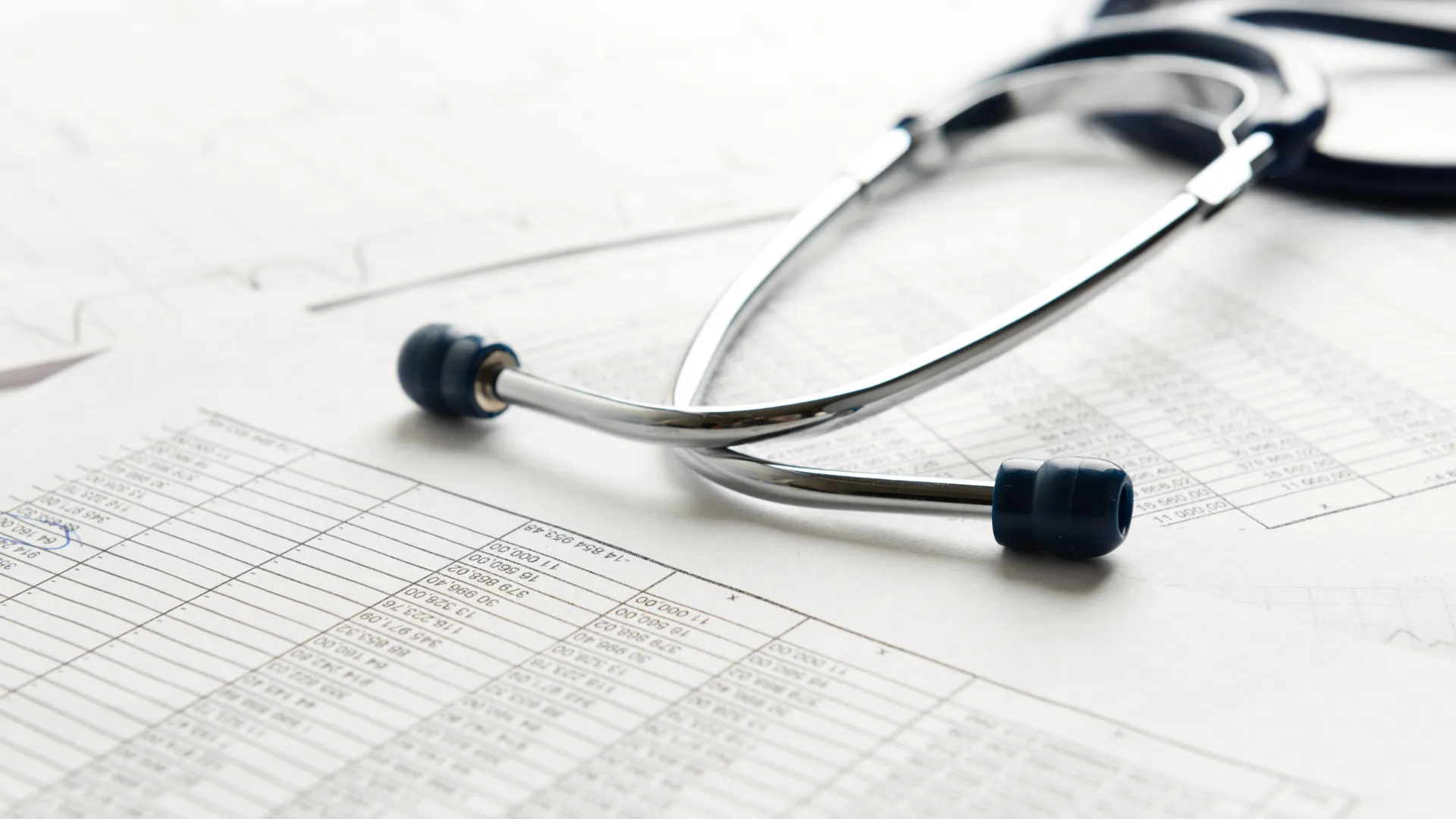 A stethoscope sits atop a medical billing statement