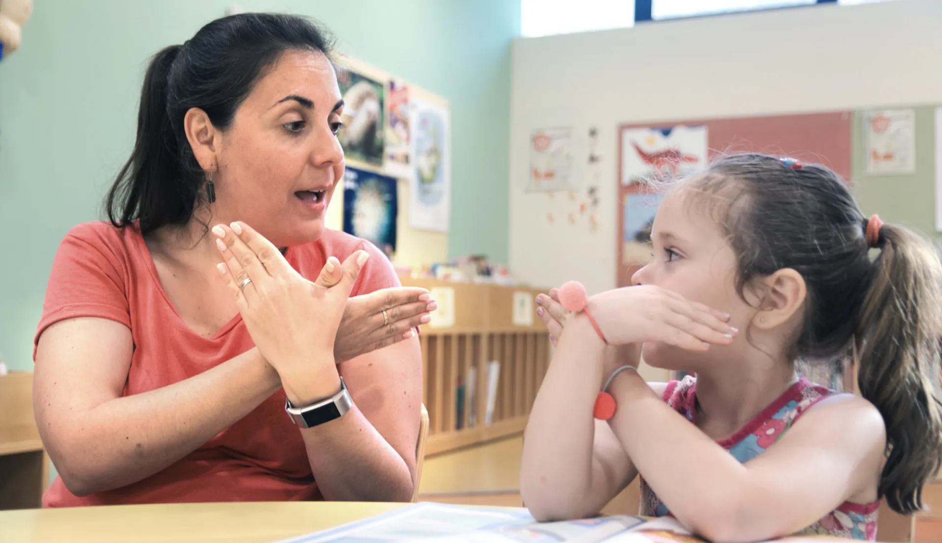educator uses sign language with a young student
