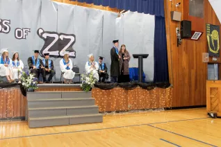 young man in cap and gown accepting award