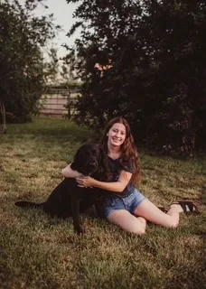 Young woman sitting outside with dog.