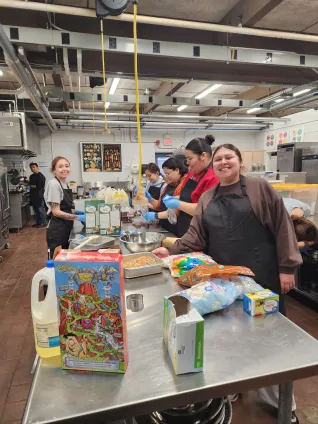 Members of the United Tribes Technical College Student Education Association work together in a campus kitchen to prepare food during a chapter activity, building teamwork while serving their community.