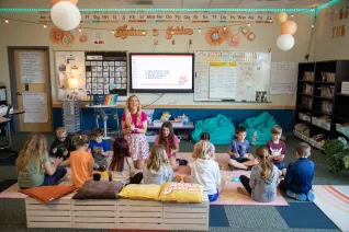 students sitting on classroom floor with teacher